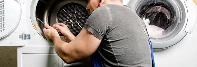 Dryer repair technician fixing a clothes dryer drum in Kansas City, KS
