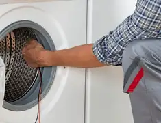 Dryer repair technician diagnosing and servicing a clothes dryer in Kansas City, KS
