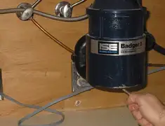 Garbage disposal repair technician tightening the mounting ring under a sink in Kansas City, KS