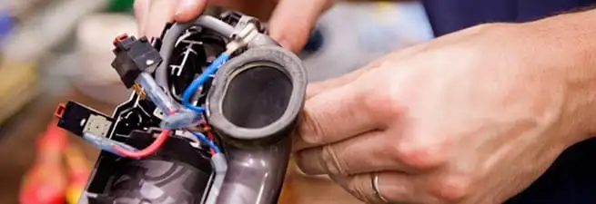 Vacuum repair technician reconnecting wiring and components in Kansas City, KS