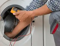 Washing machine repair technician testing a front-load washer with diagnostic tools in Kansas City, KS